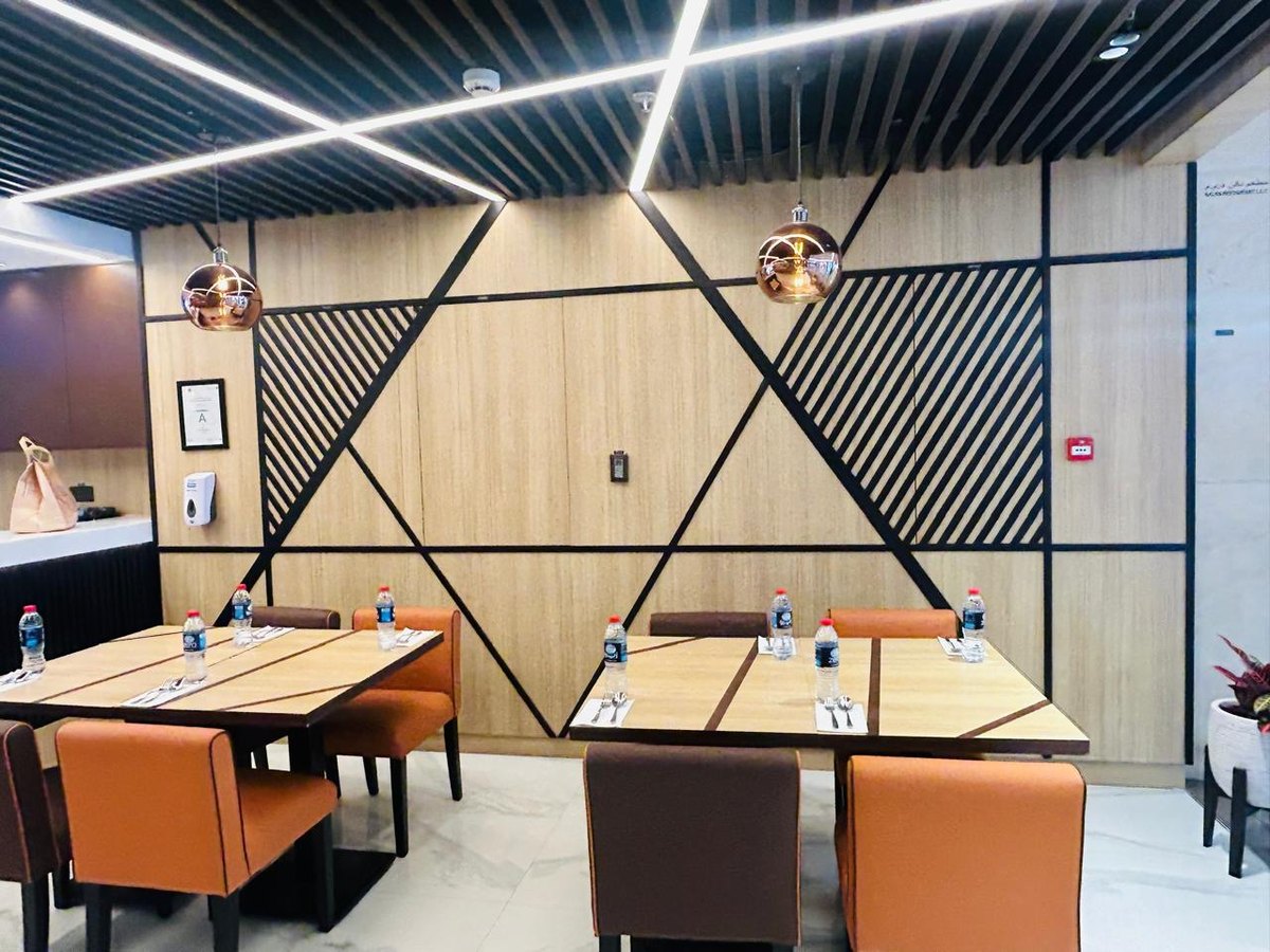 Restaurant interior in Dubai with banquette seating, timber panelling and tables supplied by ELEVE