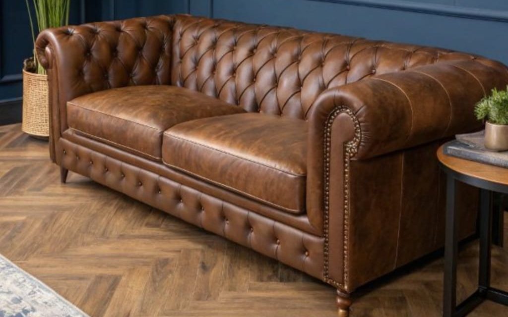 Tan leather Chesterfield sofa with deep-buttoned back, rolled arms and brass nail-head trim