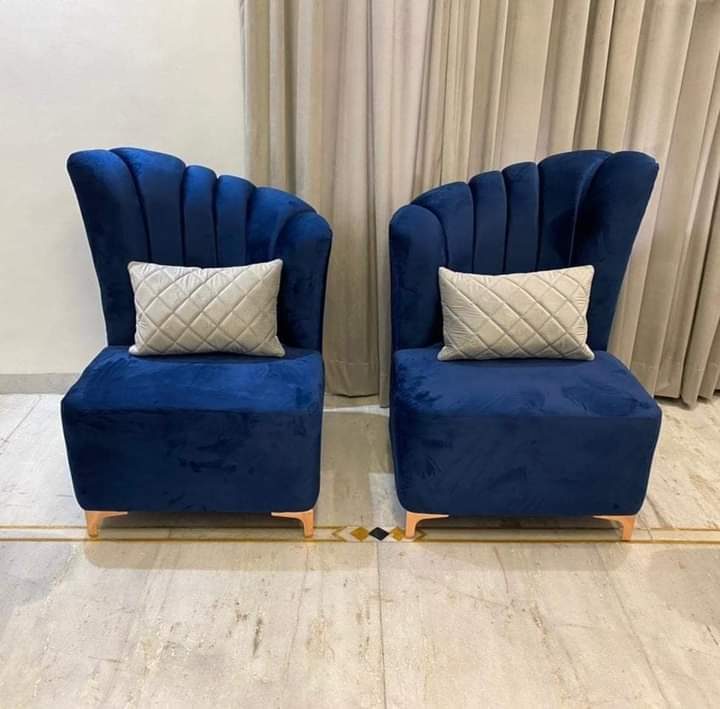 Pair of navy velvet shell-back accent chairs with channelled backs and scatter cushions