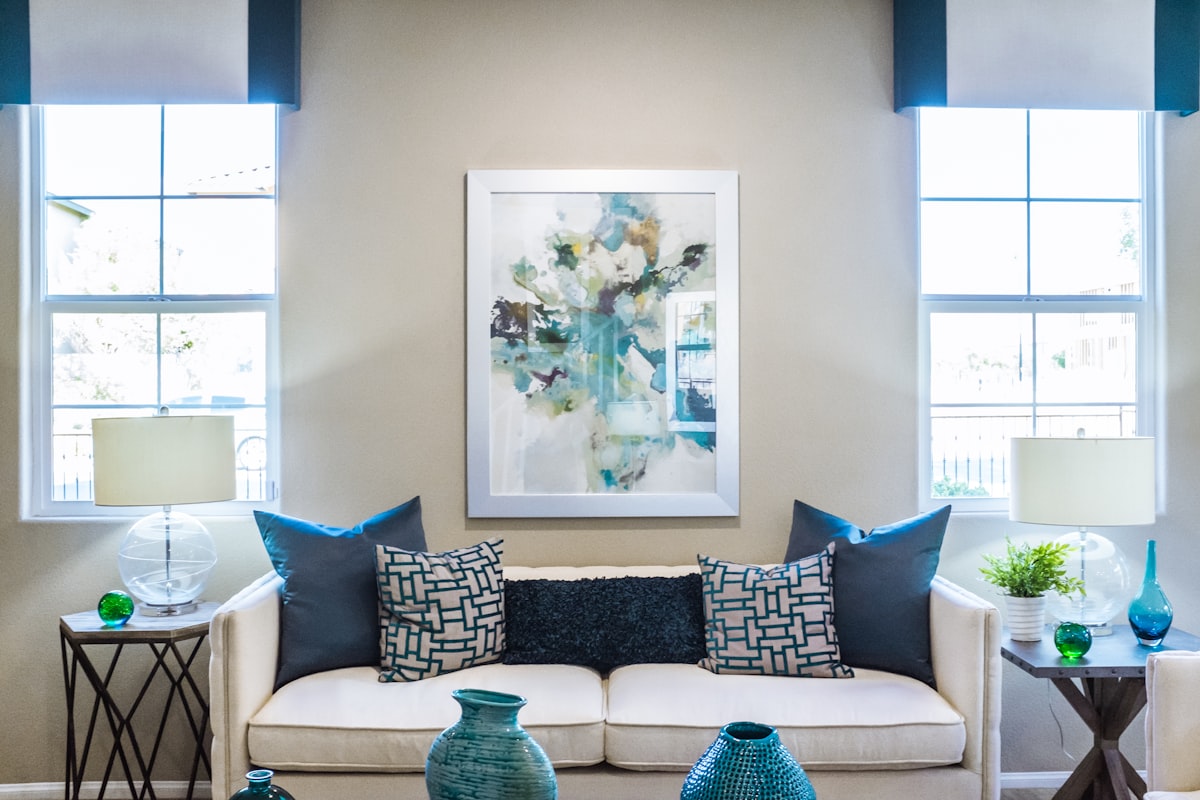 White linen sofa with teal and navy accent pillows in styled interior